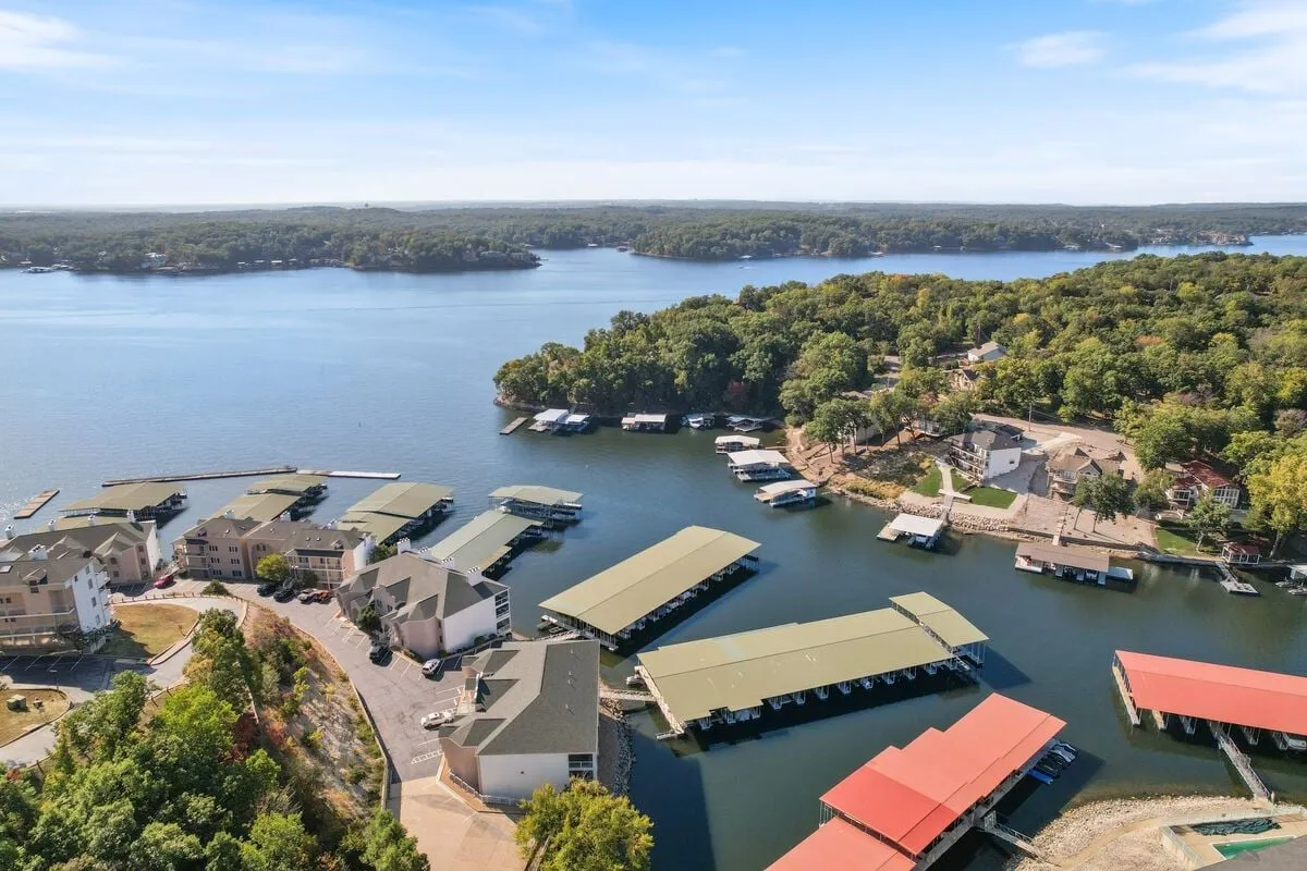 A tranquil vista overlooking the lake, with multiple boats, marinas, and a surrounding forest. The image conveys the vastness of the lake, easy access to water activities, and the natural beauty that awaits just outside the condo.